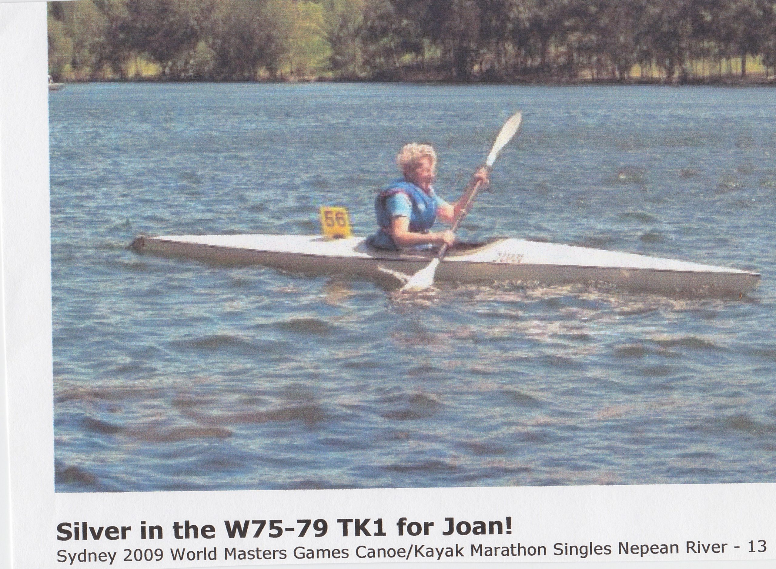 Joan paddling a white K1 with the boat number 56